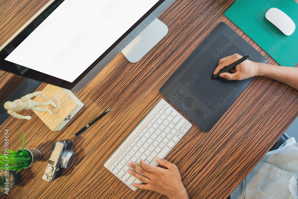 Aufkleber young graphic designer working on modern desktop computer while using graphic tablet at desk in the 