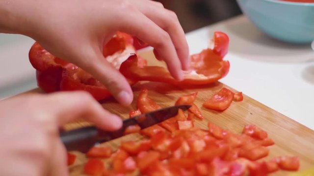 Chopping a red pepper vegetable on a cutting board