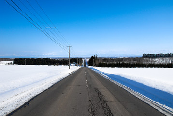 冬の道東の一本道と知床連山の遠望（北海道）