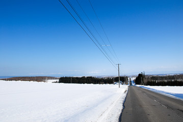 冬の道東の一本道と知床連山の遠望（北海道）