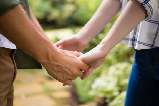Mid-section of couple holding hands