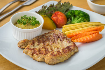 Barbecue pork steak on plate served with mashed potato and vegetables
