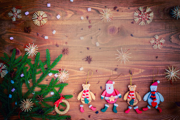 Christmas background with straw decorations, spices, marshmallow on old rustic wooden board, top view, copy space