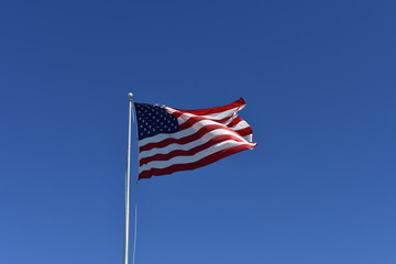 Giant United States of America Flag on clear blue sky with copy space