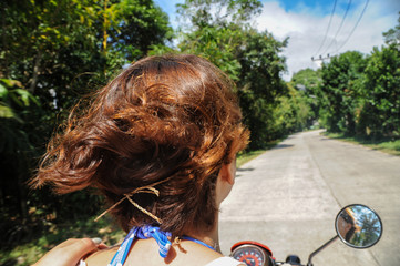 curly hair girl riding  motorcycle  in summer 2
