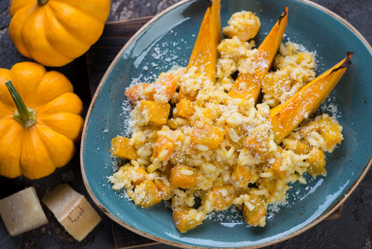 Top view of risotto with pumpkin served on a turquoise plate, closeup, horizontal shot