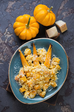 Pumpkin risotto with parmesan cheese on a brown stone background, above view