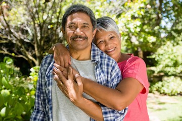 Senior couple embracing each other in garden on a sunny day