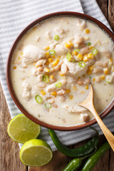 white chili chicken with cannellini beans and corn close-up in a bowl. Vertical top view