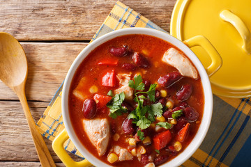 Soup of chicken with chili, beans, corn and tomatoes close-up in a bowl. horizontal top view