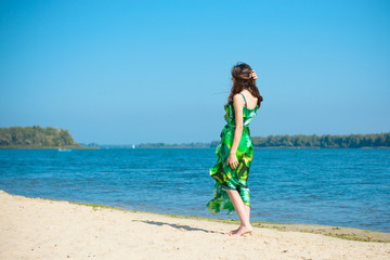 A middle-aged woman with a lean figure on vacation enjoys life and a good day in the beams of the sun