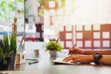 Young graphic designer working on modern desktop computer while using graphic tablet at desk in the office.	