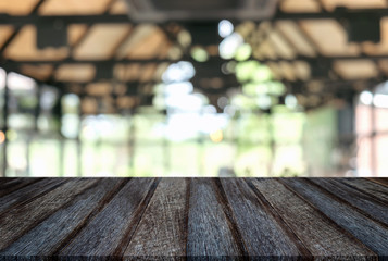 Empty old black wooden table and blur background of abstract in front of restaurant or coffee shop, cafe  can be used Mock up for display of product or for montage