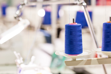 Spools of blue threads on sewing machine, factory