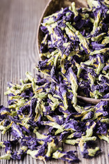 Dried blue butterfly pea flowers on wooden background