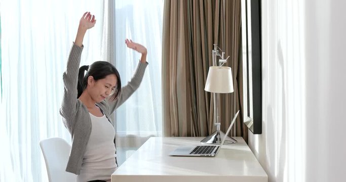 Woman stretching hand after using laptop computer at home