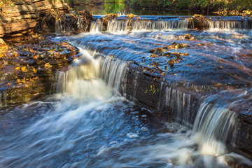 Waterfall on a river with autumn leaves