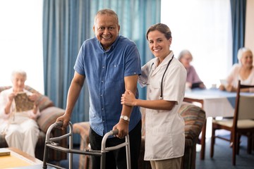 Portrait of smiling female doctor standing by senior man with