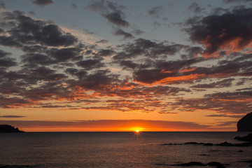 Fototapeta na wymiar Reddish dawn in the sea and with clouds. Atmospheric phenomena concept