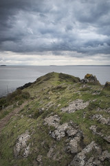 Looking out to sea at stormy dramatic sky over landscape