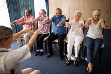 Female doctor exercising with senior people