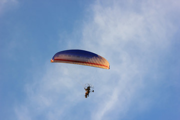 Silhouette of paraglider soaring  at sunset