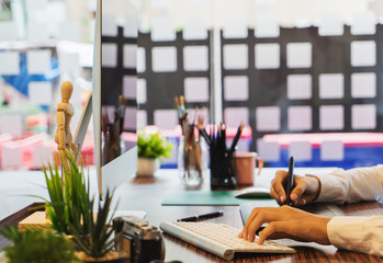 Young graphic designer working on modern desktop computer while using graphic tablet at desk in the office.	