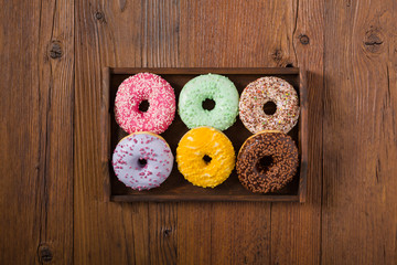 Colorful donuts on a wooden background.