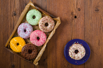 Colorful donuts on a wooden background.