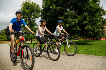 Obraz premium Healthy lifestyle - people riding bicycles in city park 