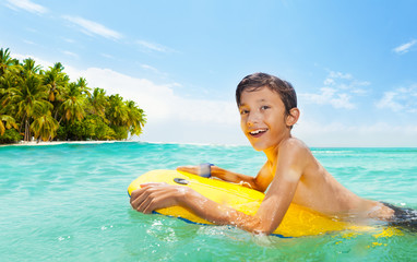 Boy swim on body board in the sea and smile