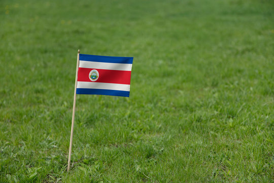 Costa Rica flag, Costa Rican flag on a green grass lawn field background. National flag of Costa Rica waving outdoor