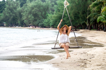 girl on the swing on the beach of Thailand