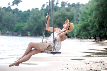 girl on a swing on the beach of Thailand