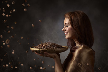 Happy woman with roasted coffee beans .