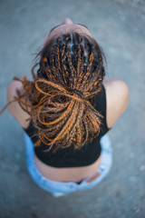 Beautiful young woman with hairdread hair dreadlocks, sunny open, no face