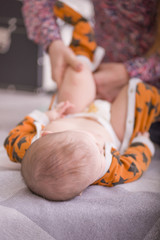 Mom puts pajamas on the baby. To wear pajamas. Courtship for the child. dressing. small happy baby