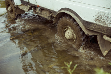 truck SUV for tourists passing through the ford river in the forest. wheel covers for dirt. large protectors.