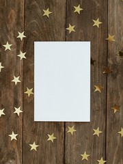 Mock up greeting card on wood rustic background with Christmas gold stars confetti. Invitation,...