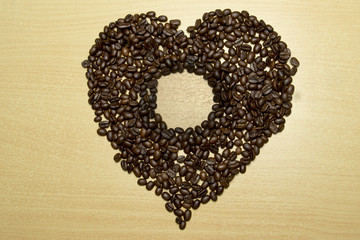 coffee concept - roasted coffee beans and coffee cup in the middle with shape love. 