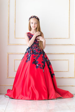 Cute little redhead girl wearing an antique princess dress or costume.
