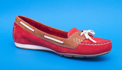 Red ballet shoes isolated on the blue background.