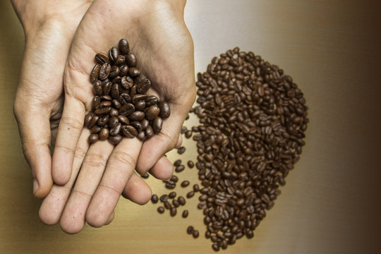 coffee concept - roasted coffee beans and coffee cup in the middle with shape i love. 
