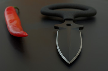 Black and red. Military composition. Black background and red chili pepper.