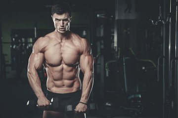 Fototapeta na wymiar Handsome model young man posing in gym