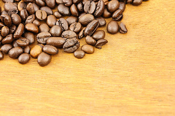 Coffee beans on brown wood background with copy space.