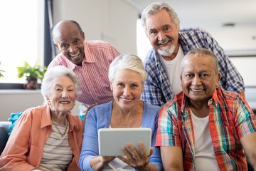 Smiling senior people with digital tablet