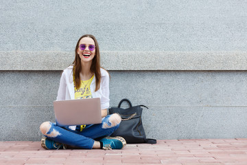Happy hipster young woman working on laptop