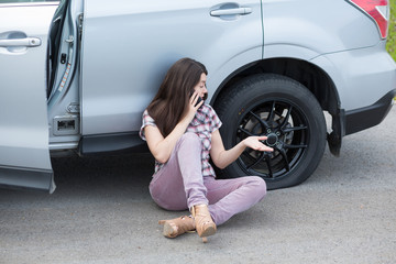 Woman With Flat tire On Car Phoning For Assistance