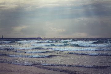 South Shields beach with breakwater and lighthouse under storm at sunset